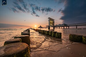 A pier extending into the water with a viewing platform and a large billboard.