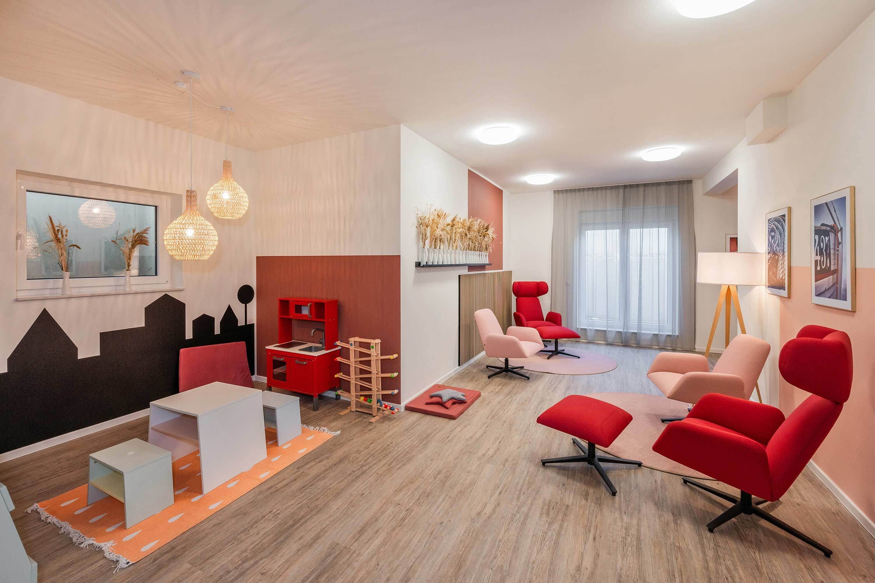 Una sala de estar moderna con un sofá, sillas, una mesa de centro, un televisor y una estantería.
