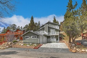 A two-story house with a front porch, a garage, and a landscaped front yard.