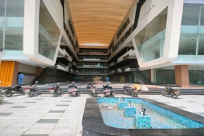 En moderne bygning med et centralt atrium, flere etager og flisegulv.