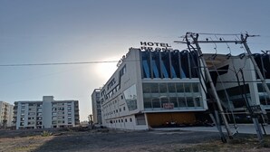 A hotel with a modern design, featuring large windows and a prominent sign indicating it is a hotel. - Hotel R R One (Vadodara)