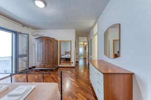 Une chambre à coucher comprenant un lit, une armoire en bois, une commode et un grand miroir.