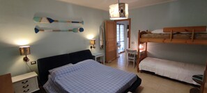 Un dormitorio con una cama individual, una litera, un escritorio y una silla.