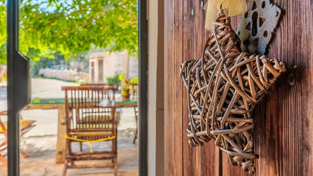 Eine rustikale Holztür mit Wanddekoration aus Bändern und einer Metallplatte.