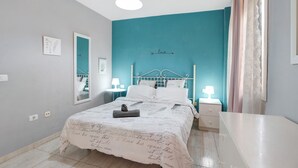 A bedroom with a bed, bedside tables, a mirror, and a wall with a word 'love' and a directional arrow. - Vacation Home "Vivienda Vacacional Atlántida" with 2 Shared Pools, 2 Private Terraces & Wi-Fi (Caletillas)