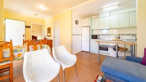 Un espacio habitable compacto con comedor, cocina y zona de estar.