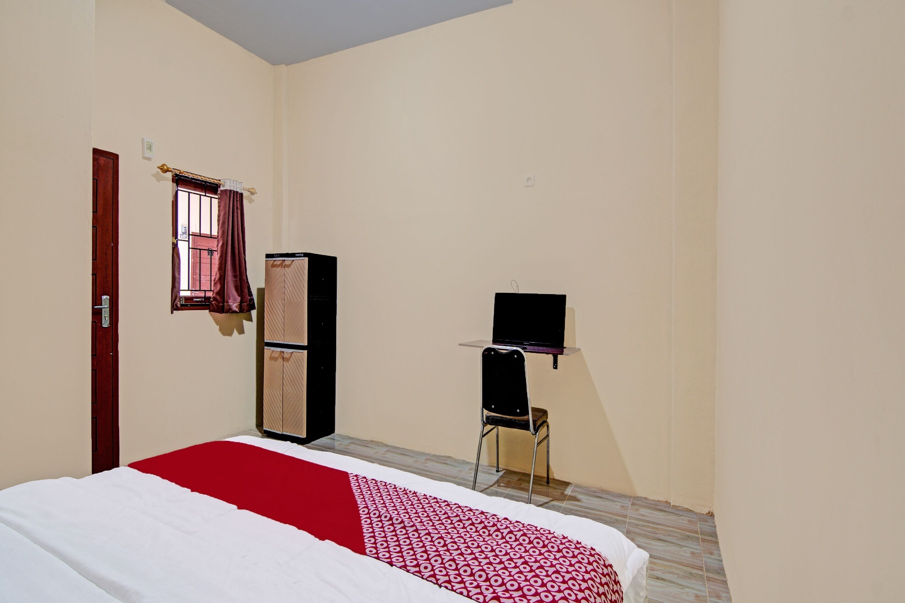 A bedroom with a bed, a wardrobe, a desk, and a chair.