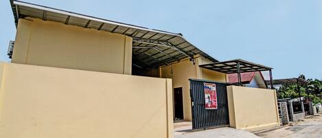 A building with a flat roof, a gated entrance, and a clear sky.