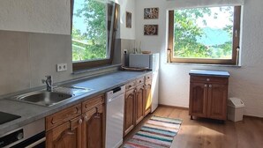 Una cucina con mobili in legno, un lavello in acciaio inossidabile e un tappeto a righe.