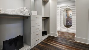 A modern, minimalist bathroom with a wooden floor, a towel rack, a vanity with drawers, and a mirror. - Penthouse w Rooftop, Private Chef, Secure Parking (Atlanta)