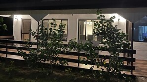Un espace extérieur abrité, doté de bancs et de plantes en pot.