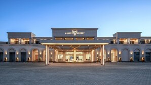 Un resort de lujo con una entrada imponente, varios arcos y una fachada bien iluminada.