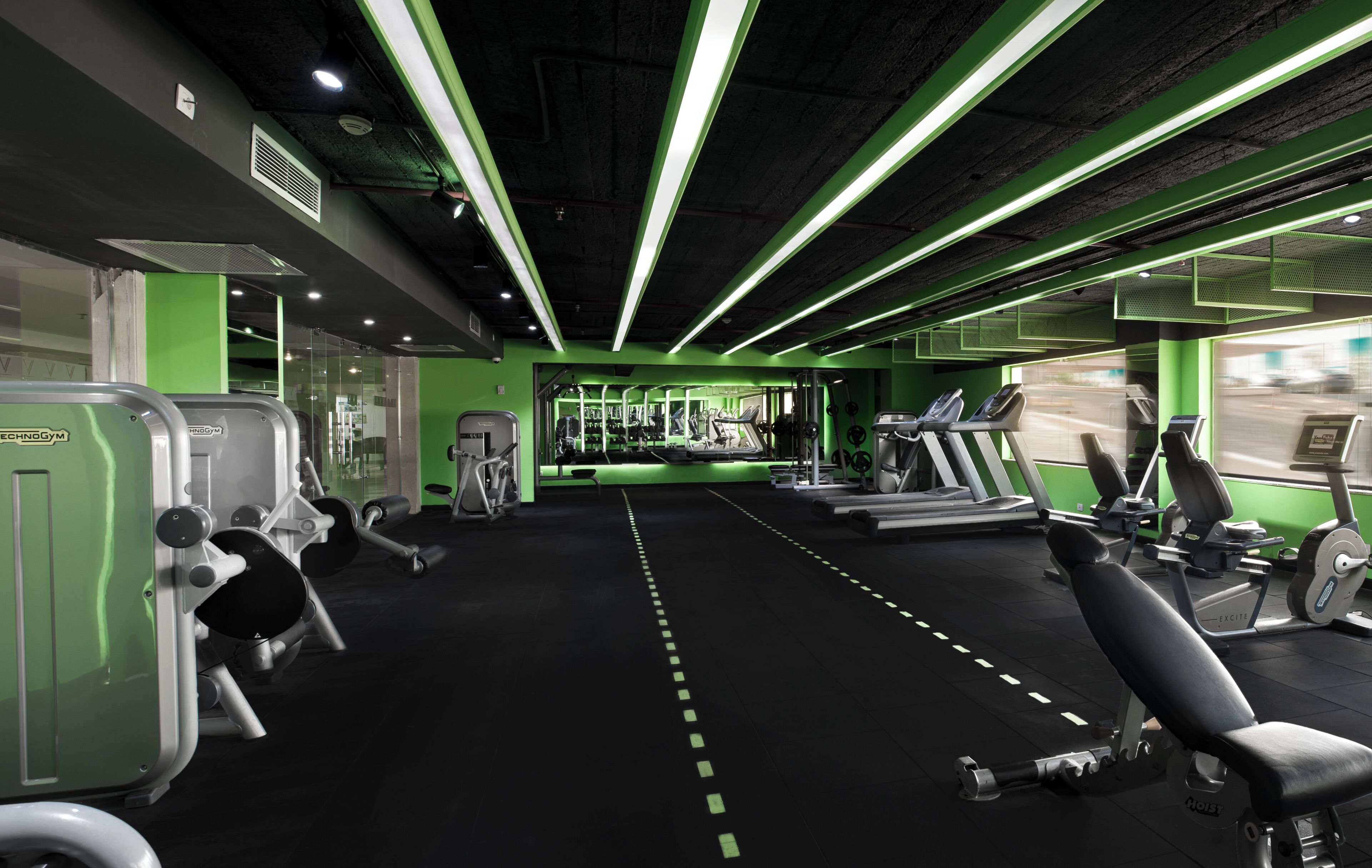 Un gimnasio con cintas de correr, máquinas de pesas y equipo de ejercicio.