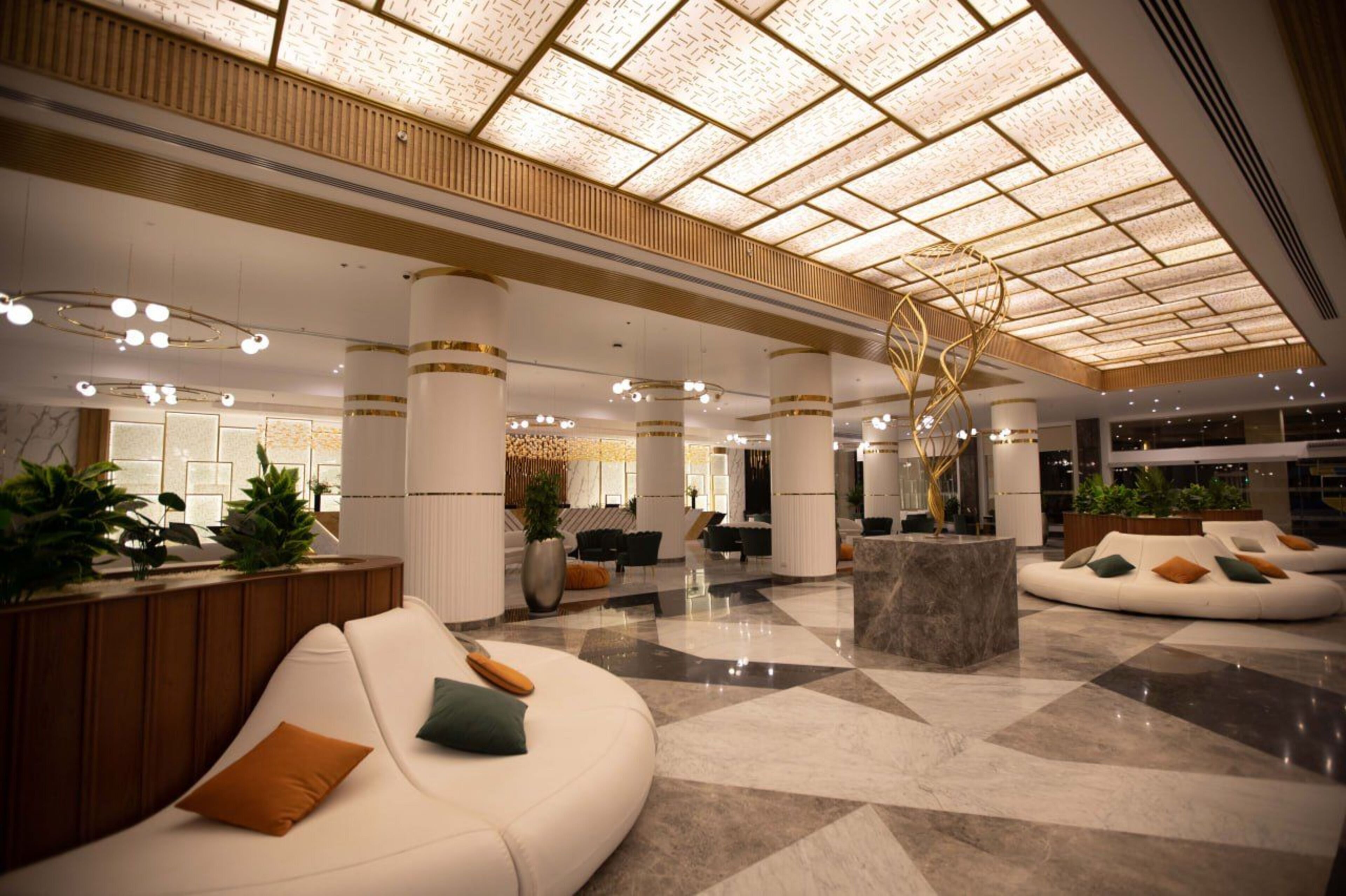 A spacious lobby with a high ceiling, large seating areas, and a modern design.