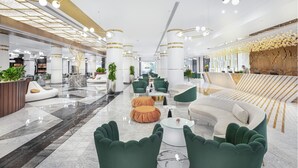 Un vestíbulo amplio con muebles modernos, un sofá curvo y una mesa de centro.