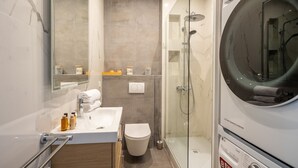 A modern bathroom with a glass-enclosed shower, a white sink, and a toilet. - Dreaming in the Daytime, by Veeve (Paris)