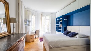 A modern bedroom with a large bed, a desk with a chair, and a wardrobe. - Dreaming in the Daytime, by Veeve (Paris)