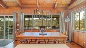 Ein Esszimmer aus Holz mit einem großen Tisch, Stühlen und einer Bank.