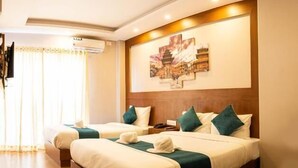 Una habitación de hotel con una cama grande, dos almohadas, un cabecero y una obra de arte colgada en la pared.