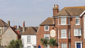 A row of traditional brick buildings with a sign reading "SEA BEACH HOUSE". - Sea Beach Cottage (Eastbourne)