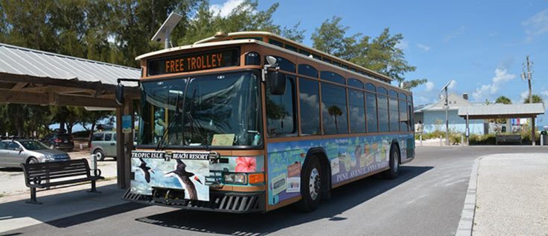 A bus with 'FREE TROLLEY' and 'TROPIC ISLE BEACH RESORT' advertisements.