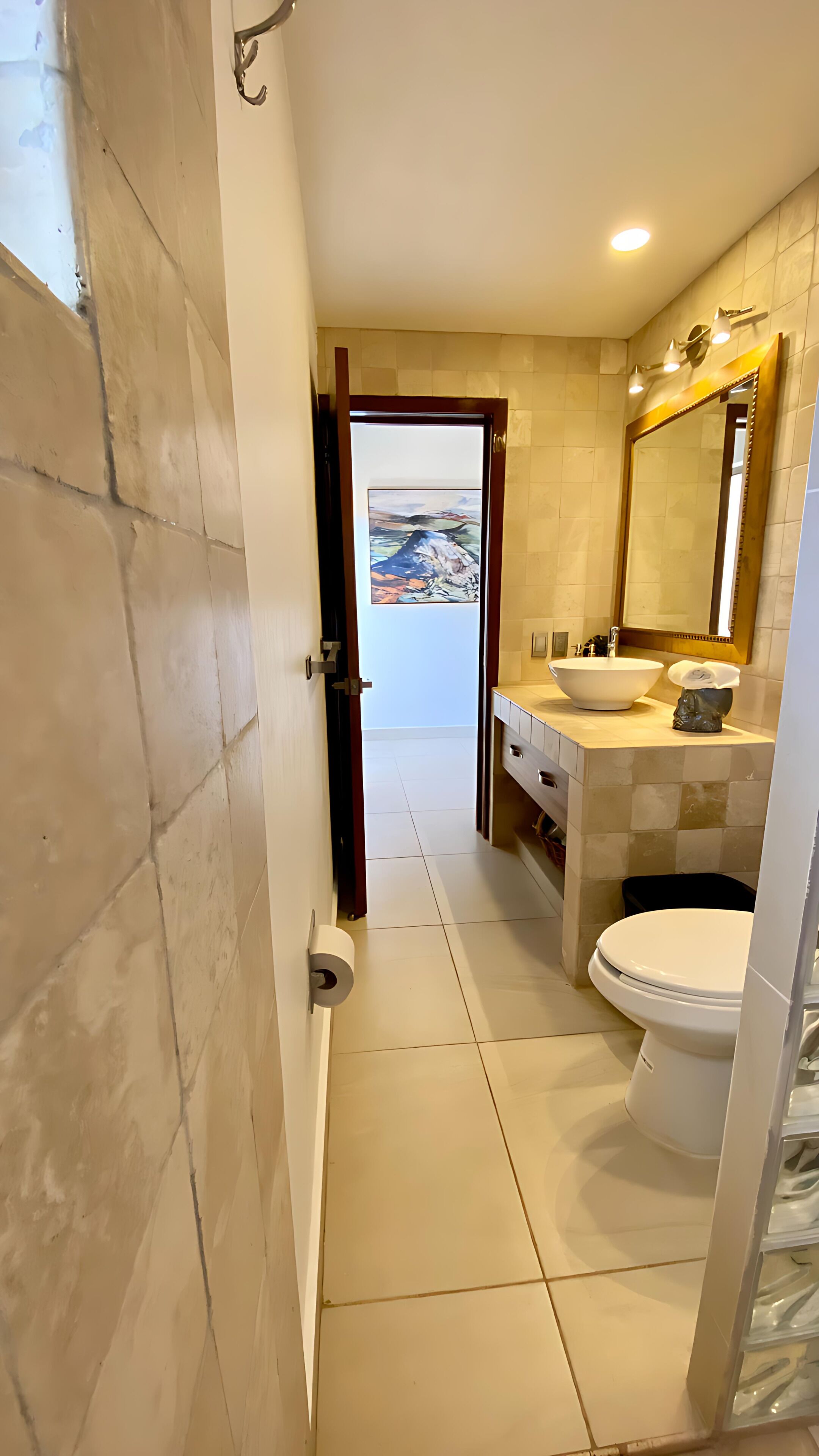 A bathroom with a toilet, sink, and a mirror.