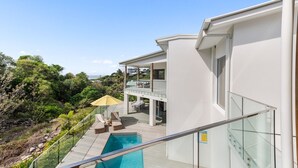Ein modernes Haus mit Balkon, Pool und Meerblick.