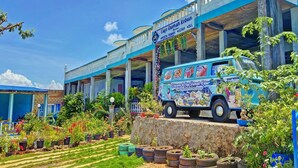 A blue van parked in front of a building with a sign reading "Cafe Rumah Kebun." - OYO 91927 Homestay Kebun (Kupang)