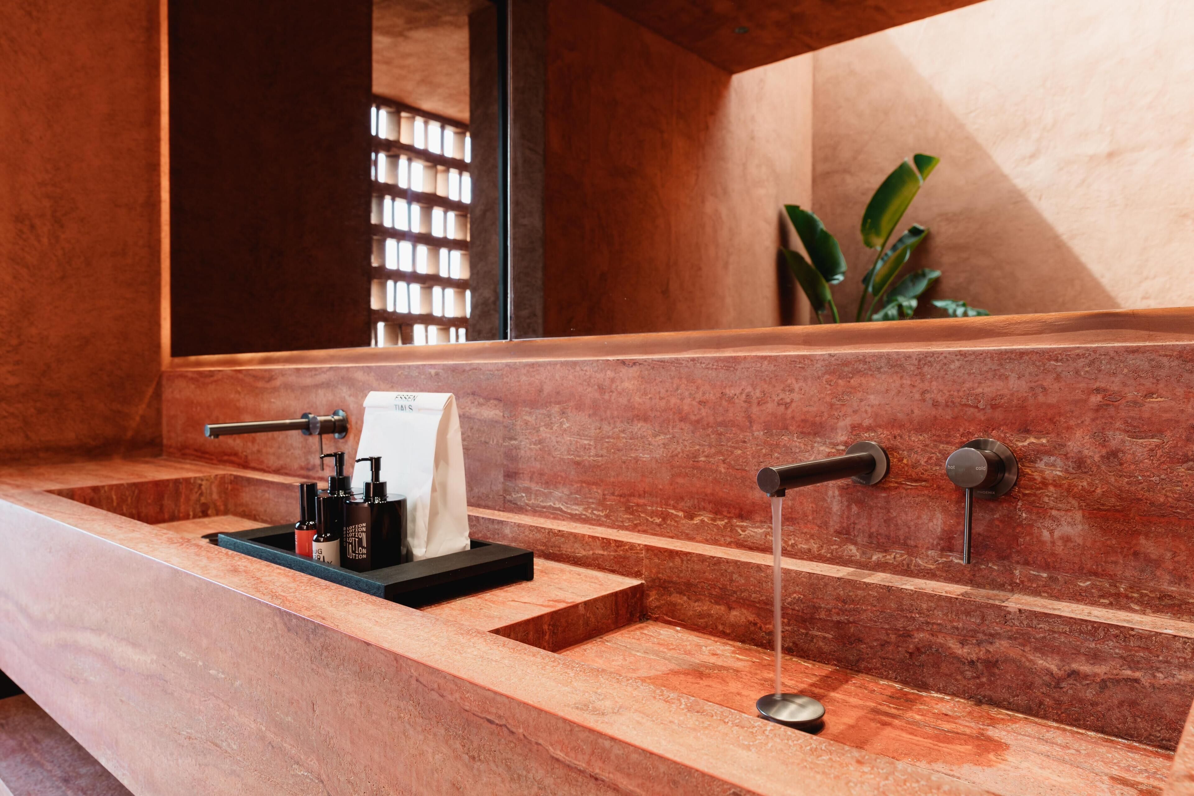 Une salle de bain avec un grand miroir, un meuble-lavabo en bois et un porte-serviettes.