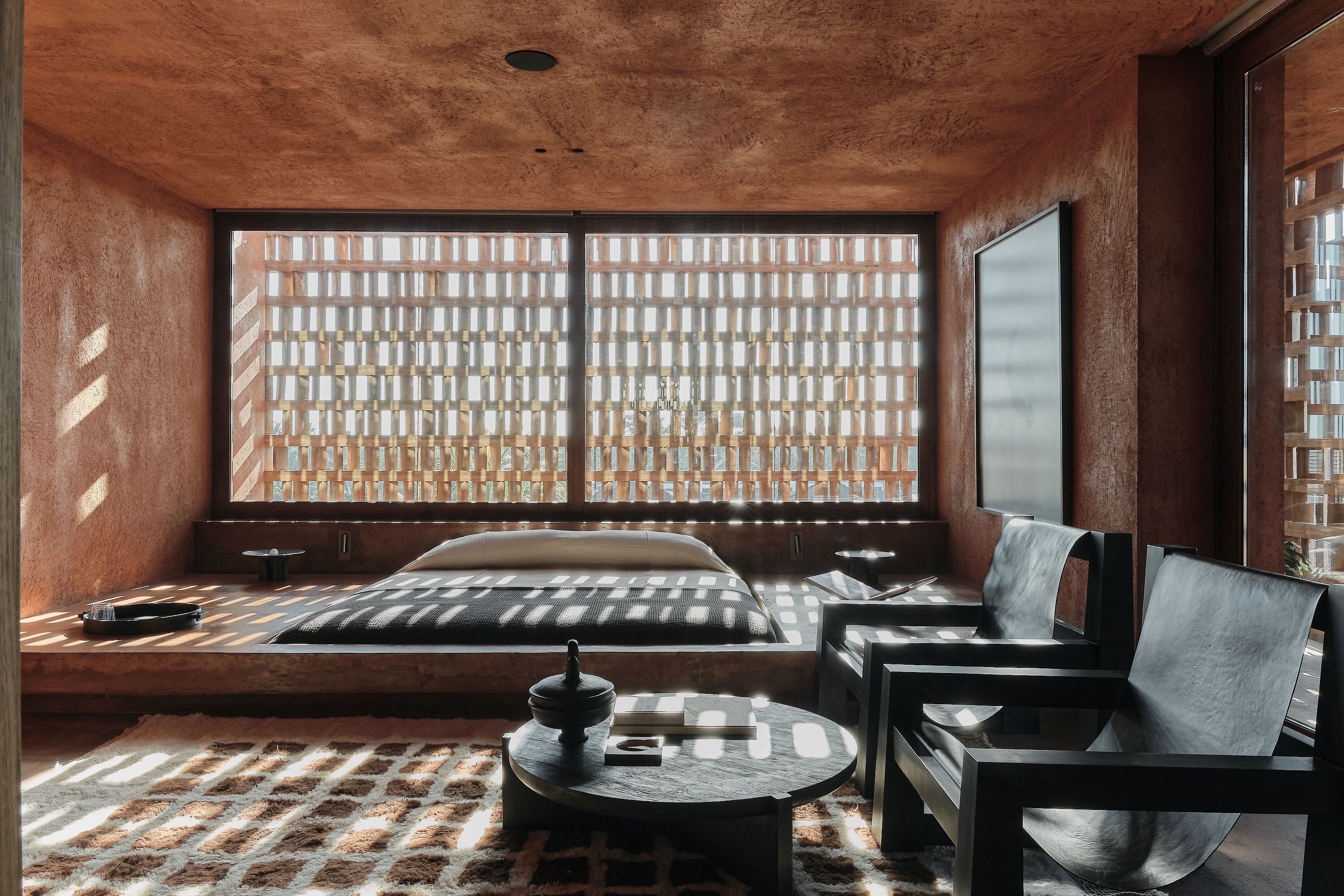 Um quarto com uma janela grande, uma cama, um sofá, uma mesa e uma cadeira.