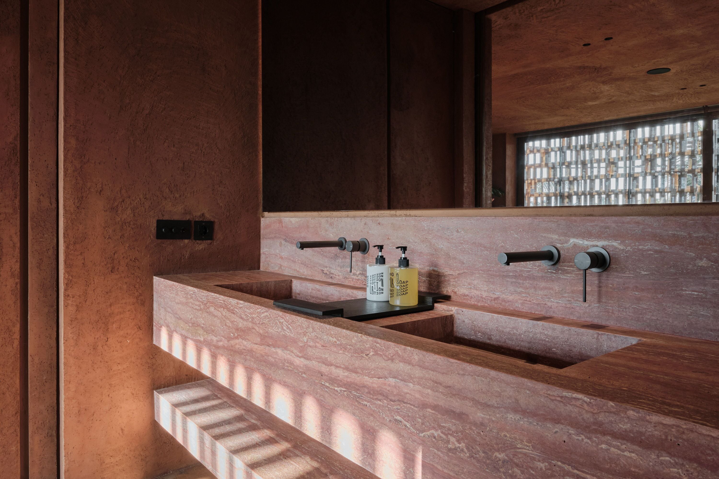 A modern bathroom with a large sink, wooden vanity, and a window with a grid pattern.