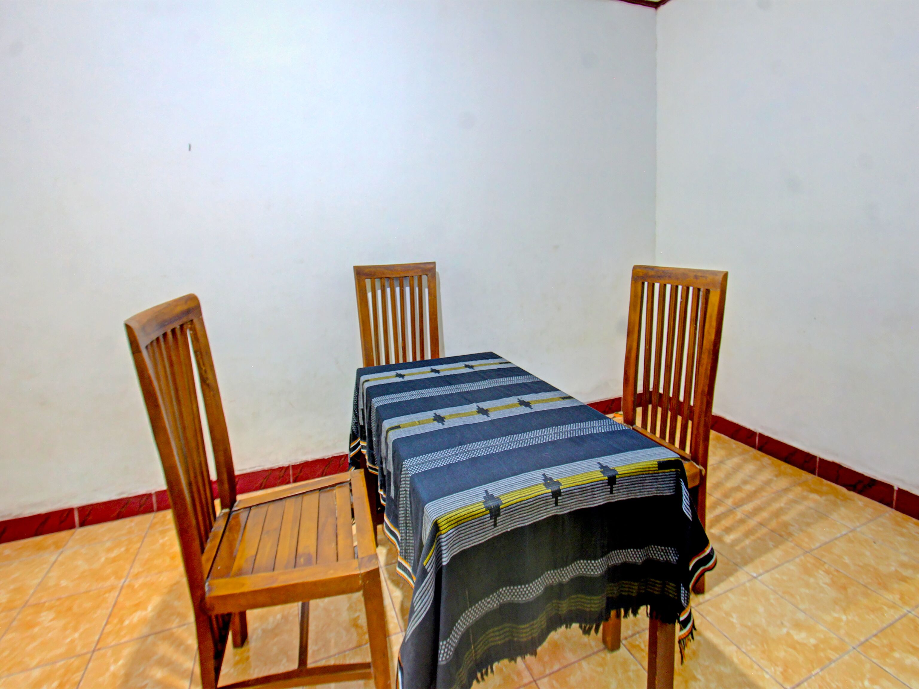 A dining area with a table and two wooden chairs.