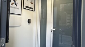 A modern elevator with a glass door, a handrail, and a control panel on the left. - Downtown apartment (Catania)