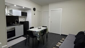 A compact living space with a kitchenette, dining area, and a sofa. - Downtown apartment (Catania)