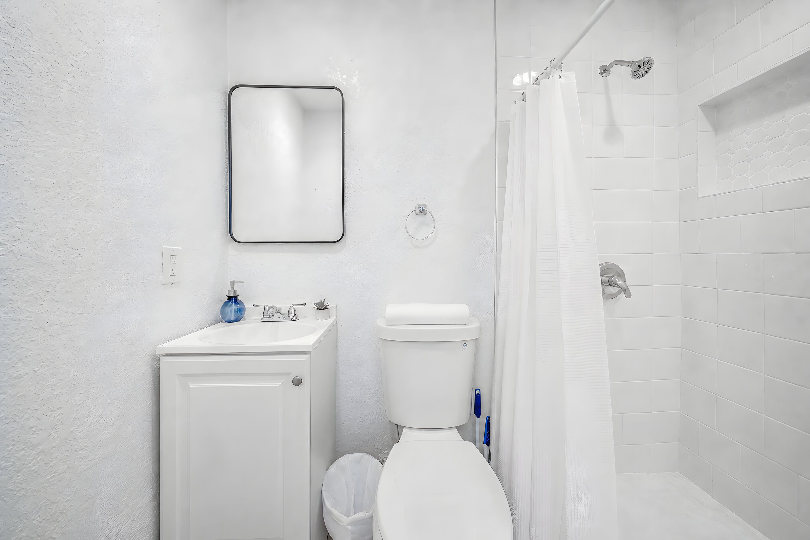 Une salle de bain avec des toilettes, un lavabo et une douche.