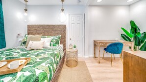 Un dormitorio moderno con cama, mesita de noche y escritorio con silla.