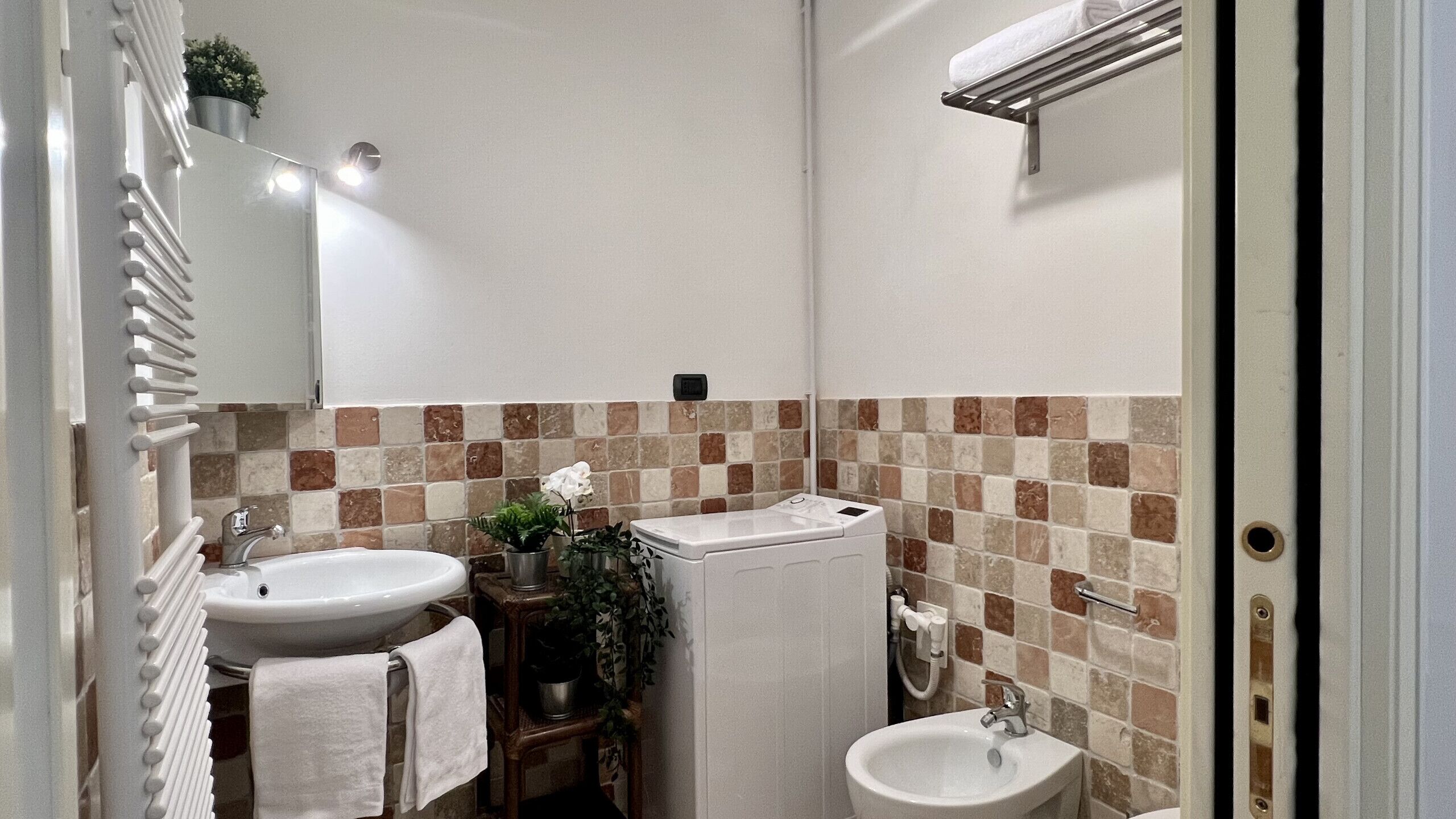 Un baño con dos lavamanos, un espejo, un perchero para toallas y una zona de ducha.