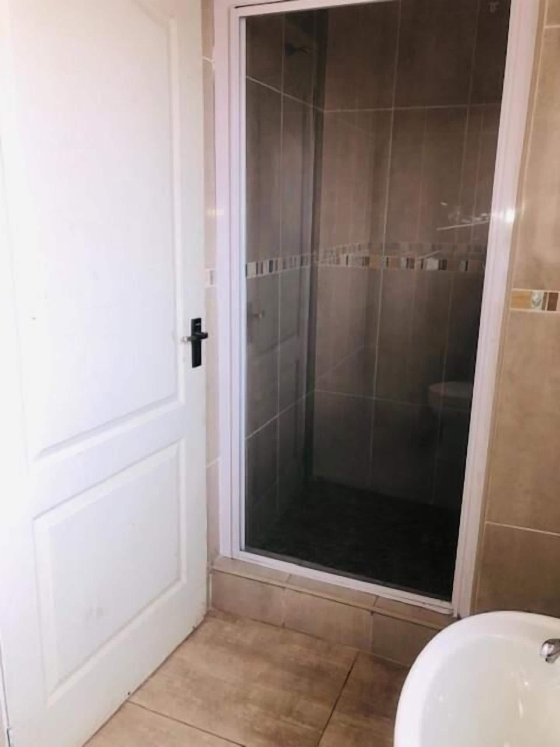 Un baño con cabina de ducha, inodoro y lavabo.