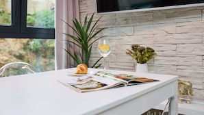 A table with a croissant, a glass of white wine, and a magazine. - Hedera A12 (Dubrovnik)