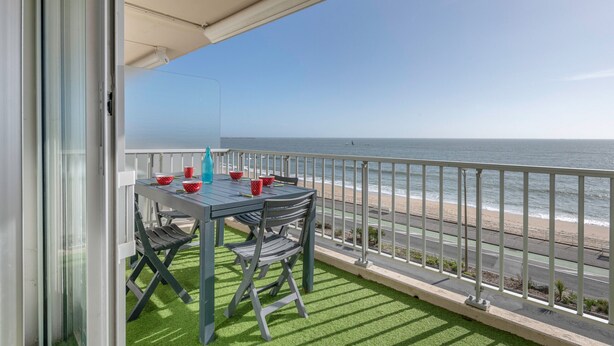 A balcony with a table and chairs, overlooking a beach and the ocean. - Seafront apartment balcony in La Baule - 6 guests (La Baule-Escoublac)