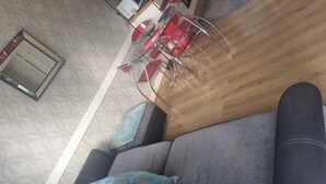Un soggiorno moderno con un divano grigio, cuscini blu e un tavolino in legno.