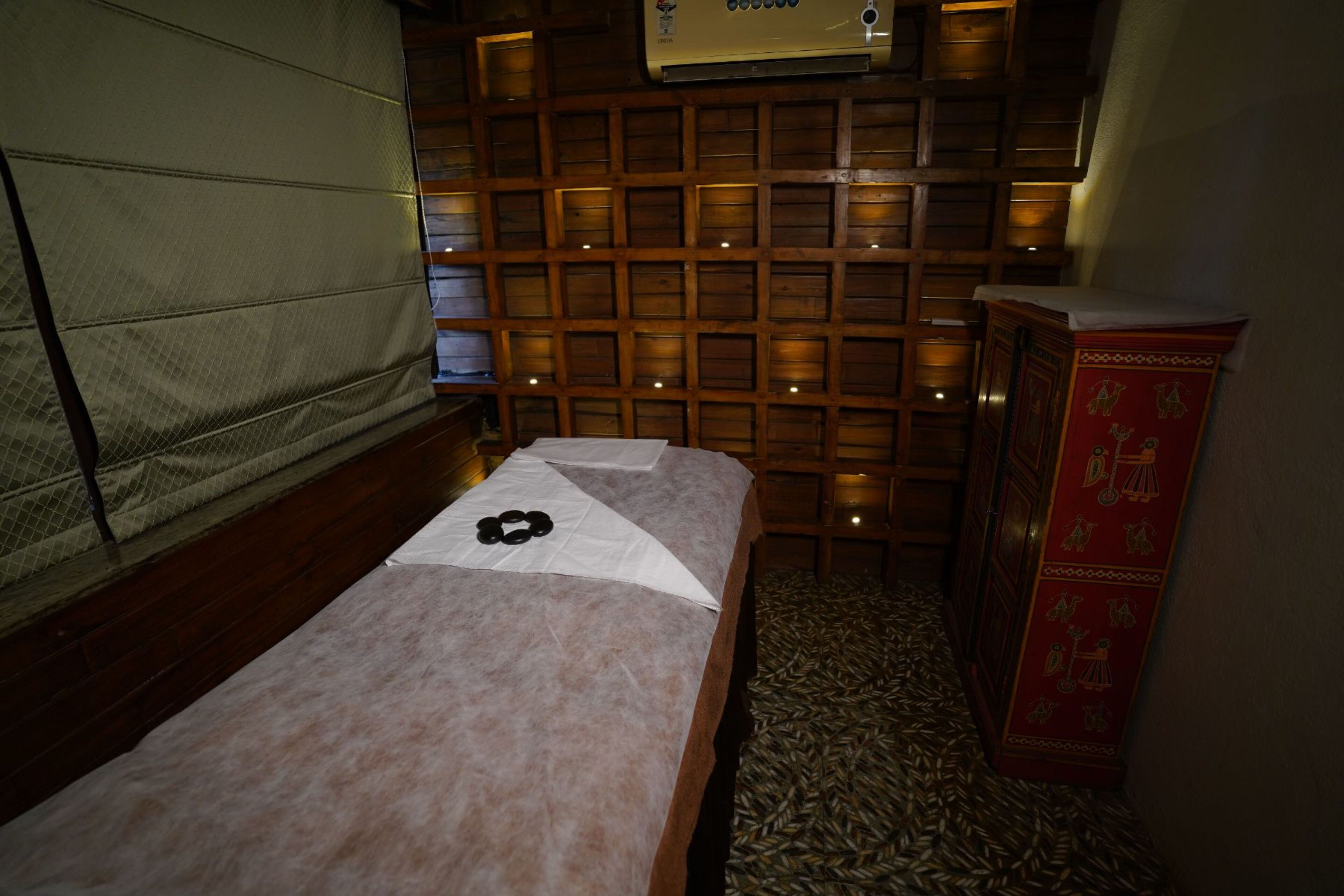 Ein Zimmer mit einem Bett, einer Holzwand mit Gittermuster und einem roten Schrank.