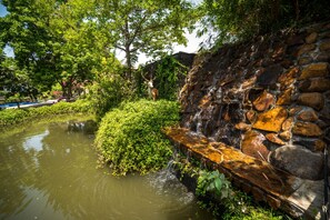 Surround yourself with nature's serenity, featuring a soothing waterfall and lush greenery.