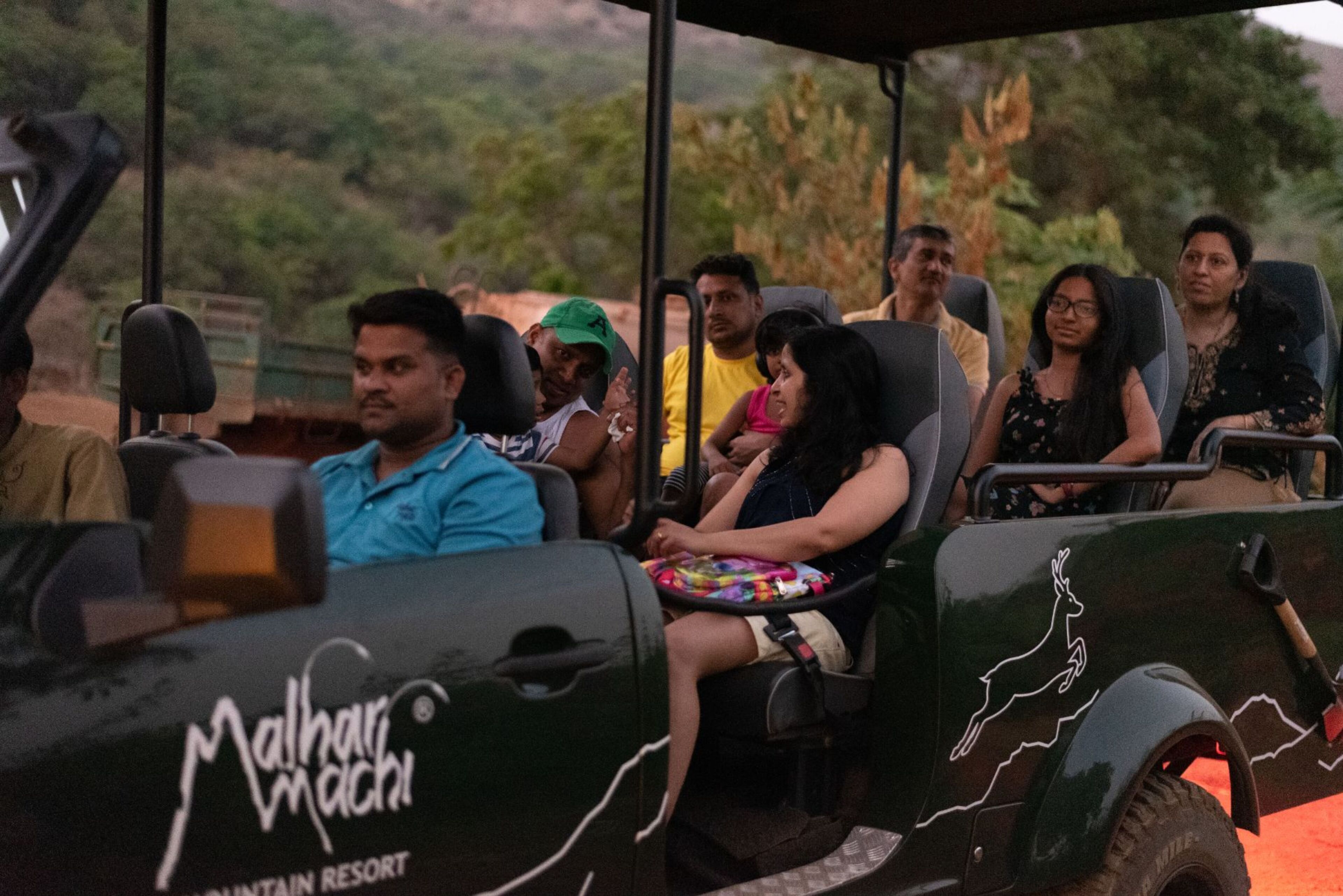 A group of people seated in a vehicle with a logo that reads "Mallahari Resort."