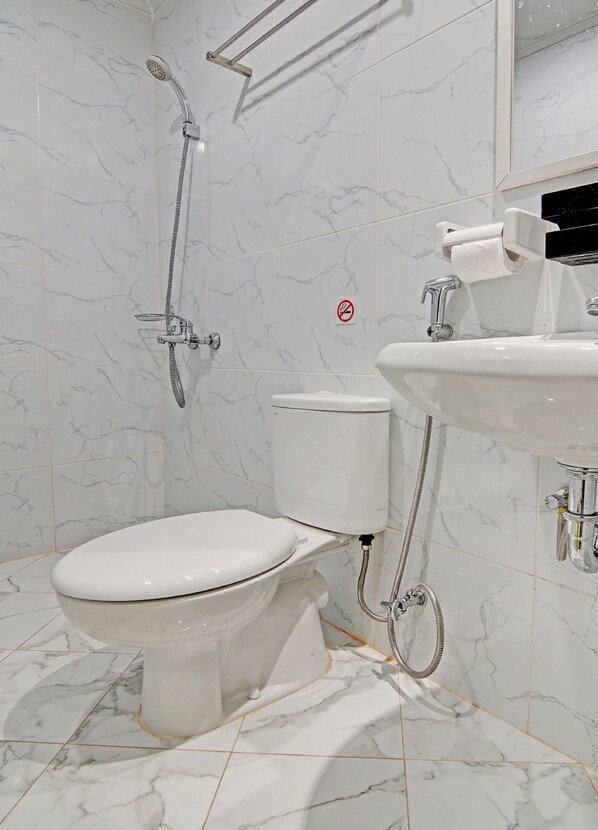 Un baño con inodoro, ducha y lavamanos.