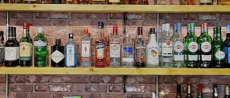 Shelves stocked with various liquor bottles, a coffee machine, and snack packets.
