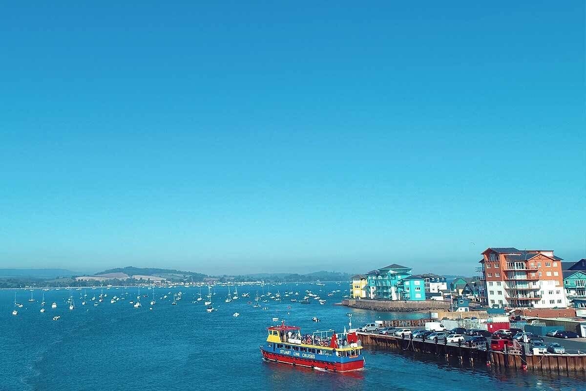 A coastal town with colorful buildings, a pier, and a ferry boat.