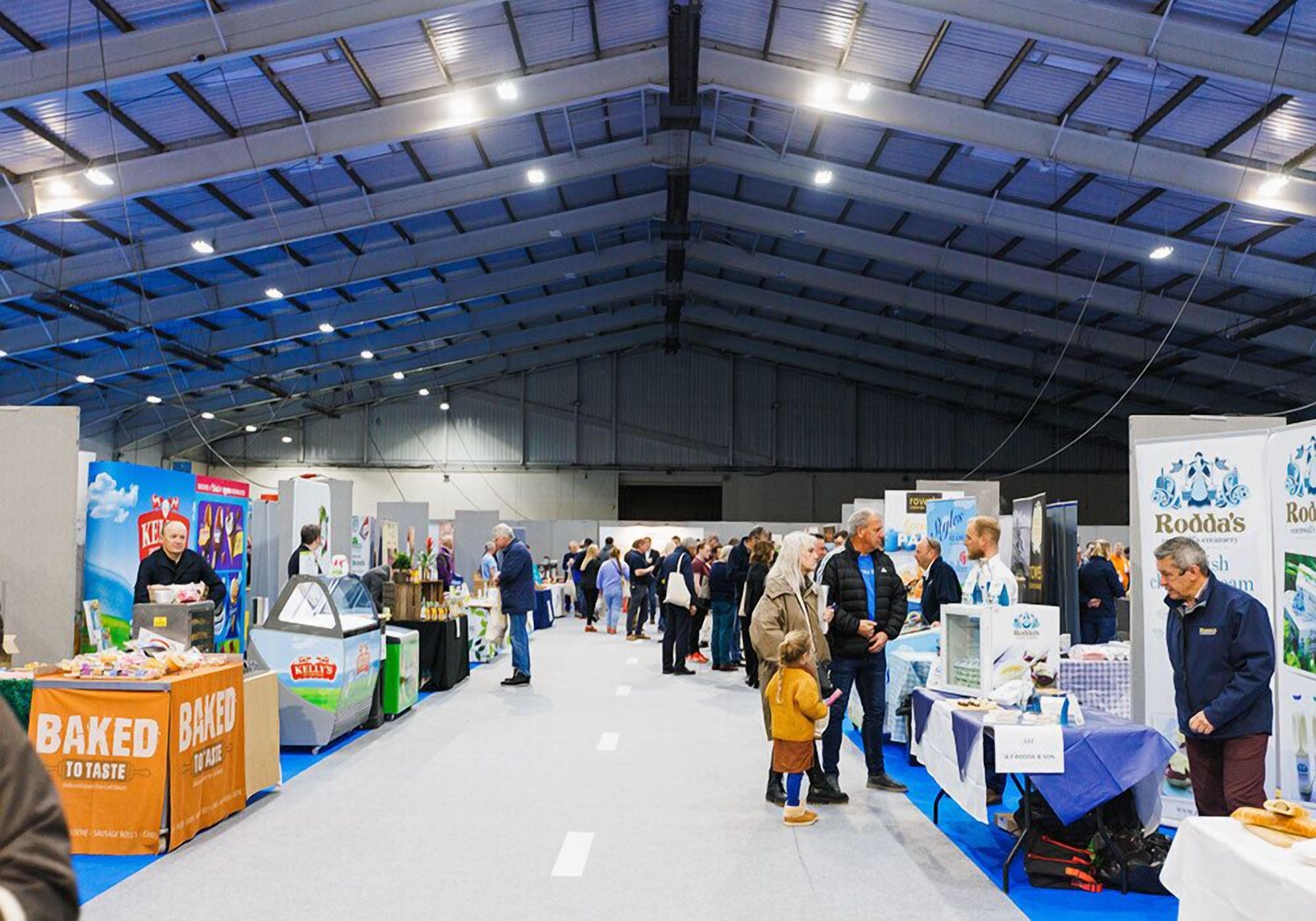 A large indoor exhibition hall with high ceilings and industrial lighting.