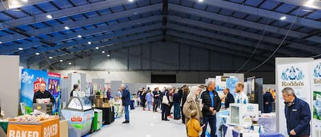 A large indoor exhibition hall with high ceilings and industrial lighting.