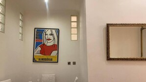 A dining area with a white table and chairs, a framed artwork on the wall, and a mirror with an ornate frame. - Stunning 2-bed Pet Friendly Apartment in Gateshead (Gateshead)